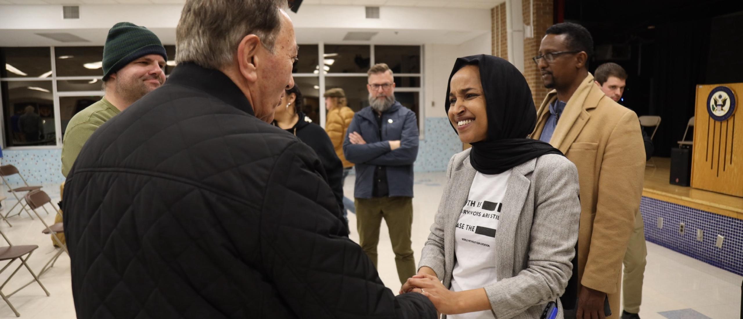 Rep. Omar shakes hands with a constituent at her February town hall in golden valley